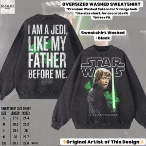 May include: Black oversized washed sweatshirt with "I AM A JEDI, LIKE MY FATHER BEFORE ME" text on the back and a Star Wars graphic on the front. The front graphic features Luke Skywalker with a green lightsaber. The sweatshirt is unisex.