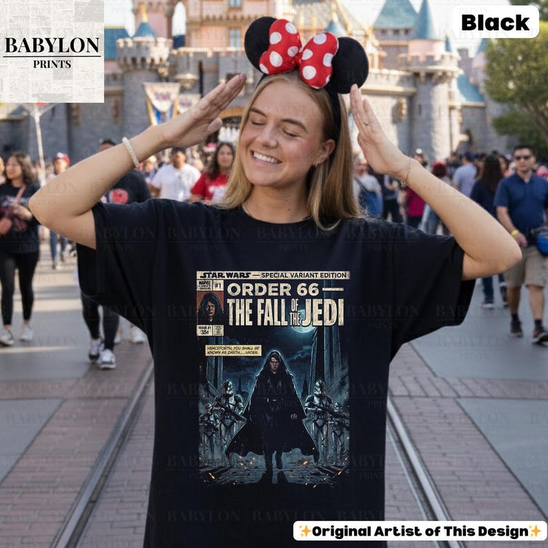 May include: Black t-shirt featuring a comic book-style graphic from Star Wars: Order 66 - The Fall of the Jedi. The design includes text and illustrations of characters and scenes from the Star Wars universe. The shirt is a special edition.