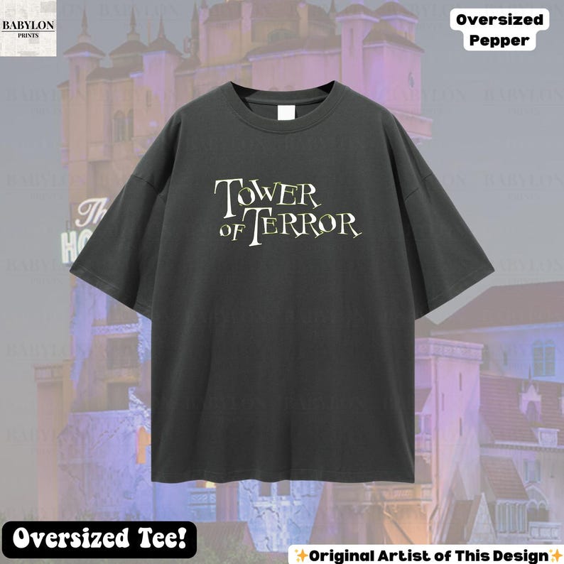 Op de afbeelding: Een donkergrijs oversized t-shirt met de tekst "TOWER OF TERROR" in een gestileerd lettertype. Het shirt heeft korte mouwen en een ronde hals. De woorden "Oversized Pepper" staan rechtsboven. De woorden "Oversized Tee!" staan onderaan.