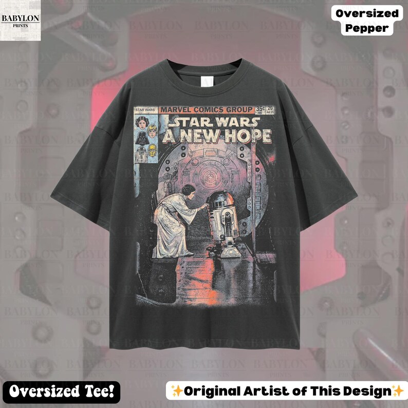 May include: Dark gray oversized t-shirt featuring a Star Wars comic book cover. The graphic includes the text "STAR WARS A NEW HOPE" and images of Princess Leia and R2-D2. The shirt also has the text "Oversized Tee!" and "Original Artist of This Design".