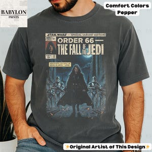 May include: A dark grey t-shirt featuring a Star Wars comic book cover design. The graphic reads "Order 66: The Fall of the Jedi" with Darth Vader and Stormtroopers. The shirt is labeled "Comfort Colors Pepper."