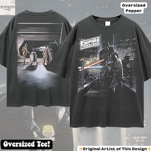 May include: Dark gray oversized tee featuring Star Wars imagery. The front displays a scene from "The Empire Strikes Back" with Darth Vader. The back shows C-3PO, R2-D2, and other characters. The shirt has the text "Oversized Pepper" and "Oversized Tee!"