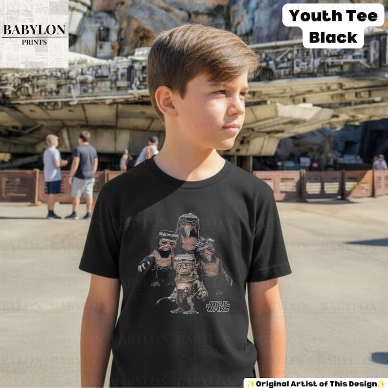 Op de afbeelding: Een zwart t-shirt met korte mouwen en een grafische print van vier Ewok-personages uit Star Wars. Het ontwerp bevat het Star Wars-logo in witte tekst. Het t-shirt is gelabeld als Youth Tee Black.