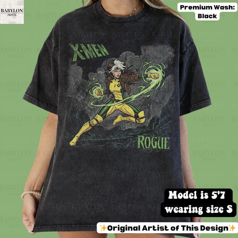May include: Black t-shirt with a graphic of Rogue from X-Men. The design includes the text "X-MEN" and "ROGUE" in green. The character is in a yellow and green costume, with green energy effects. The shirt is a premium wash.