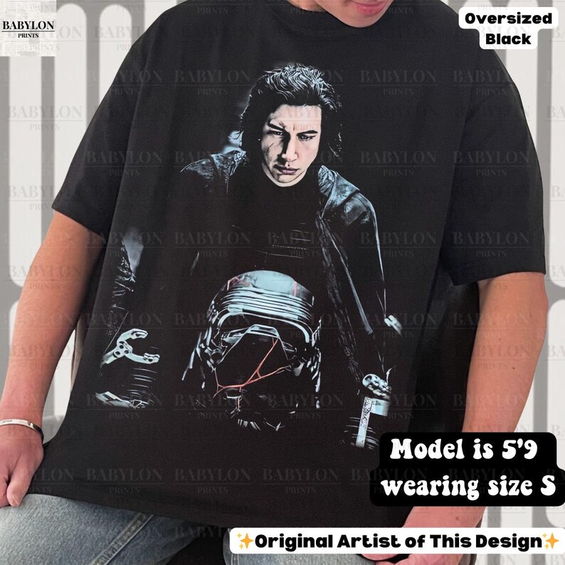 May include: Black oversized t-shirt with a graphic of a person and a helmet. The text "Oversized Black" is visible. The model is 175cm and wearing size S. The design is by the original artist.