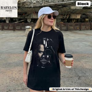 May include: A white ceramic mug with a black handle and the text "But First, Coffee" in a bold, black font. The mug is set against a blurred background, suggesting a cozy setting.