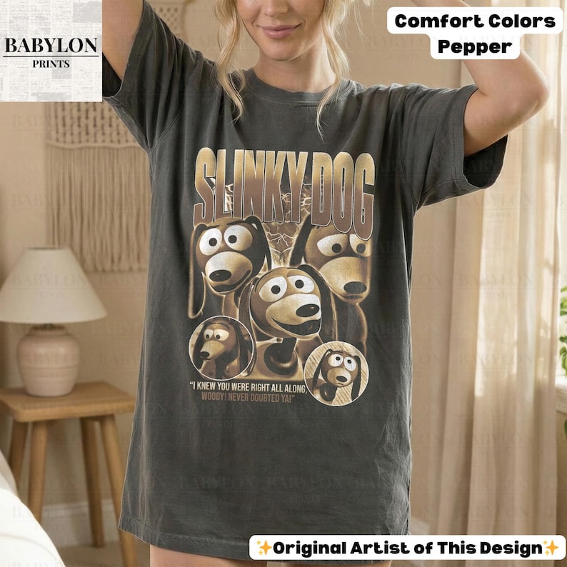 May include: Dark grey t-shirt featuring a graphic of Slinky Dog from Toy Story. The design includes the text "SLINKY DOG" and several images of the character. The shirt also has the text "I KNEW YOU WERE RIGHT ALL ALONG. WOODY! NEVER DOUBTED YA!"