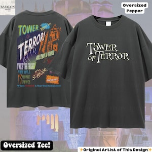 Op de afbeelding: Donkergrijze oversized t-shirt met "TOWER OF TERROR" in het wit op de voorkant. De achterkant van de shirt heeft een kleurrijke afbeelding met tekst als "Hollywood Tower" en "Twice the Fright".
