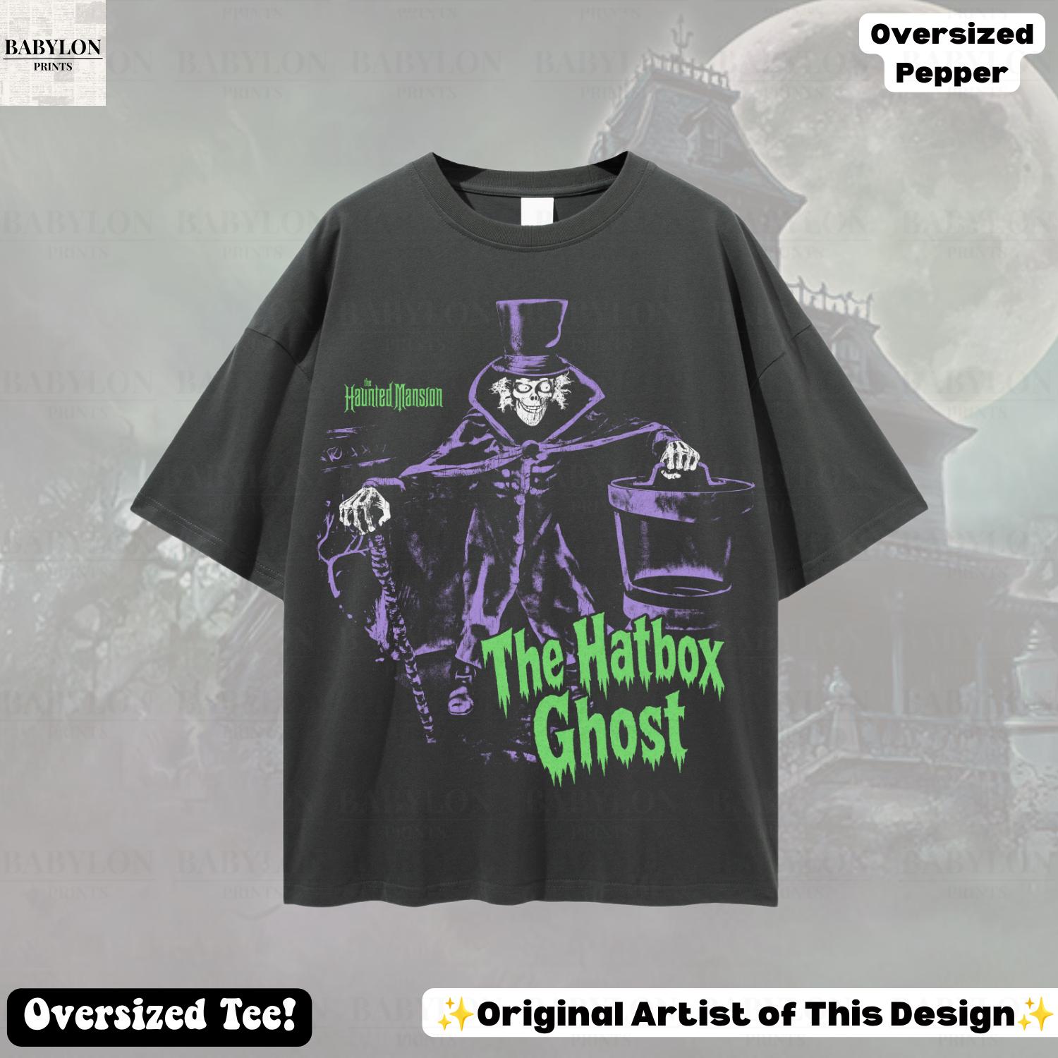 Puede incluir: Una camiseta gris carb&oacute;n de corte oversize con un gr&aacute;fico de The Hatbox Ghost de The Haunted Mansion. El dise&ntilde;o muestra al personaje con sombrero de copa, sosteniendo un bast&oacute;n y una sombrerera, junto al texto The Haunted Mansion y The Hatbox Ghost.