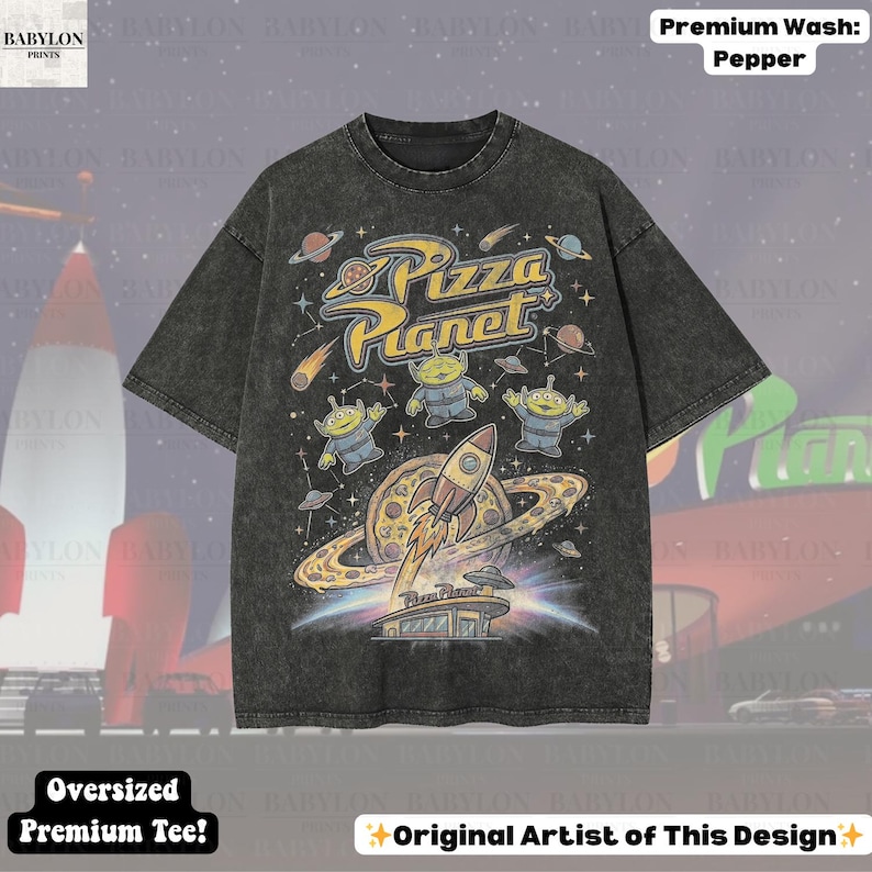 May include: A dark gray oversized t-shirt featuring a Pizza Planet graphic with aliens, a rocket, and planets. The shirt has the text "Pizza Planet" in yellow and blue. The shirt also has the text "Oversized Premium Tee!" and "Original Artist of This Design".