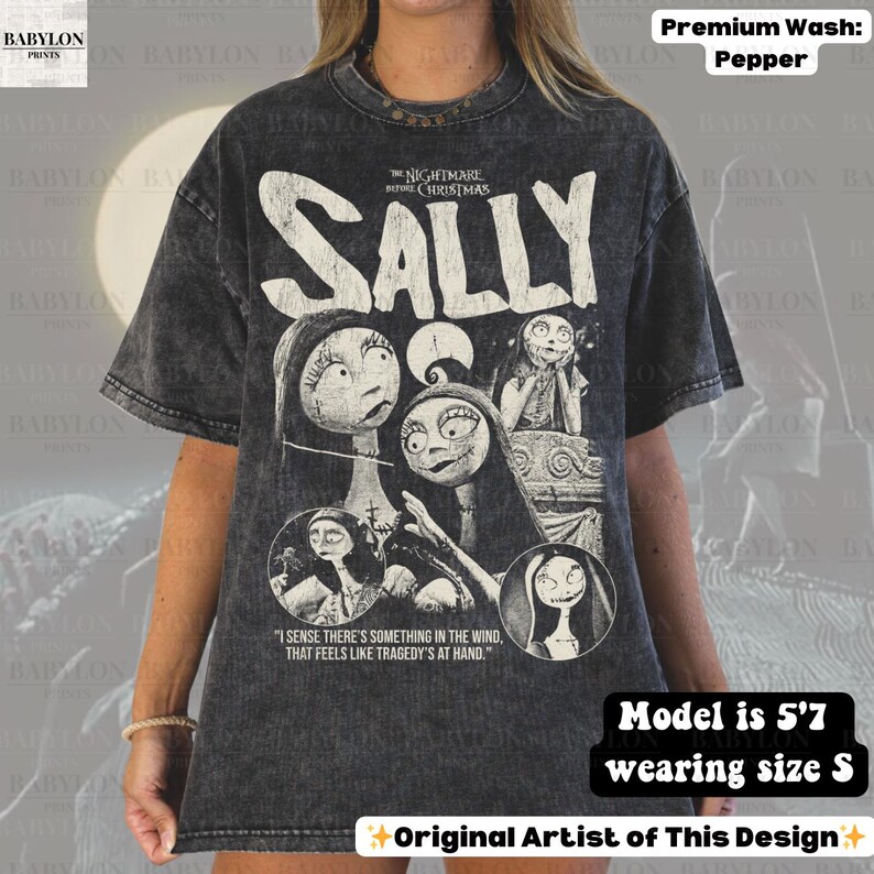 May include: Dark gray t-shirt featuring the word "SALLY" above a graphic of Sally from "The Nightmare Before Christmas." The shirt includes the text "I sense there's something in the wind, that feels like tragedy's at hand." The shirt is a premium wash pepper.