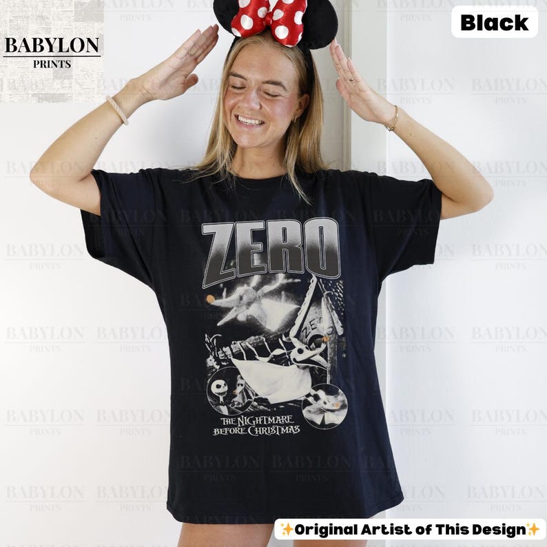 May include: Black t-shirt featuring the word "ZERO" in a silver gradient, with a graphic from "The Nightmare Before Christmas." The design includes Zero the ghost dog. The shirt is worn by a person wearing a Minnie Mouse headband.