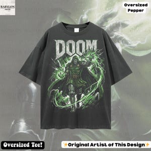 May include: Dark gray oversized t-shirt featuring a graphic of a character with the word "DOOM" in a distressed font. The character is in green and black with green lightning. The shirt has the text "Oversized Tee!" and "Original Artist of This Design".