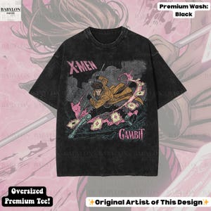 May include: Black oversized premium tee featuring a graphic of the X-Men character Gambit. The design includes the text "X-Men" and "Gambit" in pink and white. The shirt has a vintage wash and the text "Original Artist of This Design".