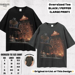 May include: Black oversized tee shirt with a large print of a building and fountain, with the text "GUSTEAU'S". The shirt is black and pepper colored. The size chart shows measurements in inches.