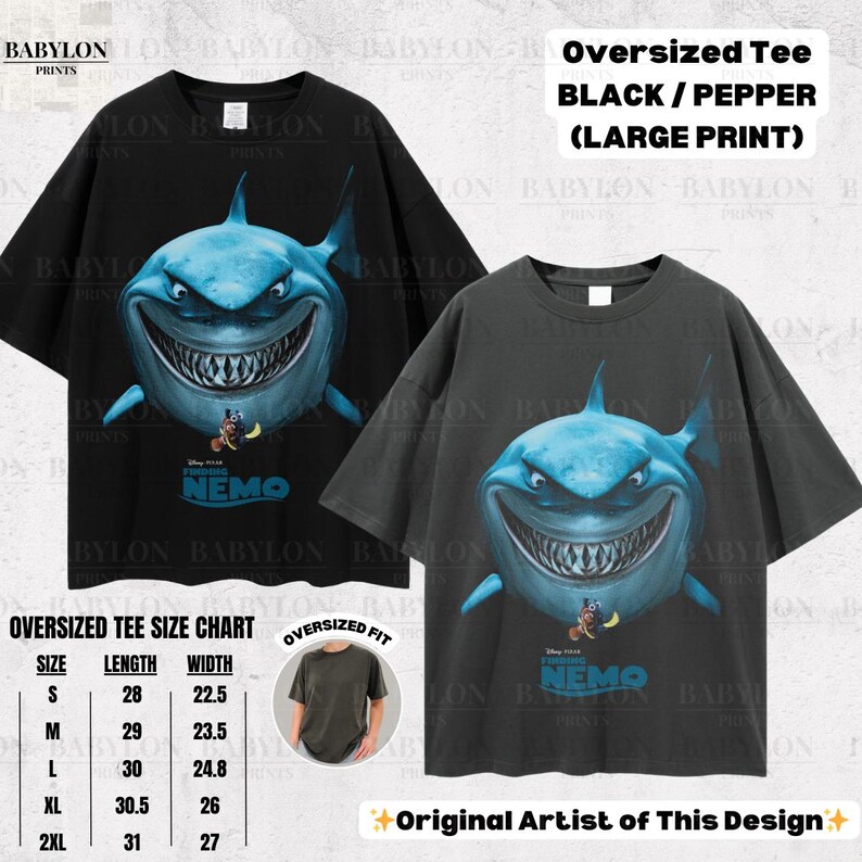 May include: Two oversized black and pepper-colored t-shirts with a large print of a shark from the movie "Finding Nemo." The shark is blue with a wide grin. The shirts have a size chart and the text "Original Artist of This Design."