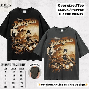 May include: Black and pepper-colored oversized tee shirts with a large print of the Disney DuckTales cartoon. The shirts have the DuckTales logo and characters. A size chart is also included.