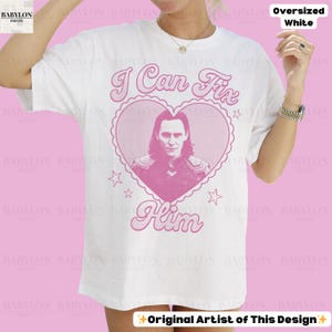 K&ouml;nnte beinhalten: Wei&szlig;es &uuml;bergro&szlig;es T-Shirt mit einem rosa herzf&ouml;rmigen Aufdruck mit einem Portr&auml;t und dem Text "I Can Fix Him". Das Shirt hat auch den Text "Original Artist of This Design".