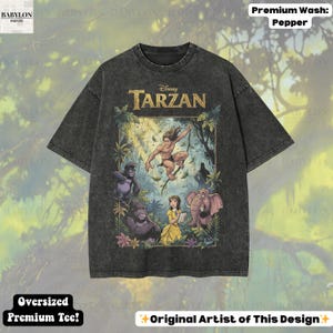 May include: Dark gray oversized premium tee featuring a Tarzan graphic. The design includes Tarzan, Jane, gorillas, and an elephant in a jungle setting. The shirt has the text "Disney Tarzan" and "Original Artist of This Design".