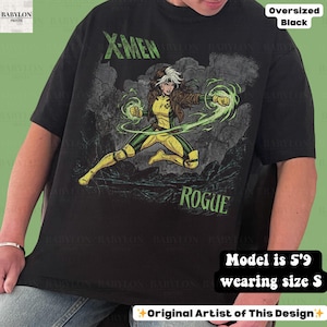 May include: Black oversized t-shirt with a graphic of the X-Men character Rogue in yellow and green, with the text "X-MEN" and "ROGUE" in green. The shirt is a size S.