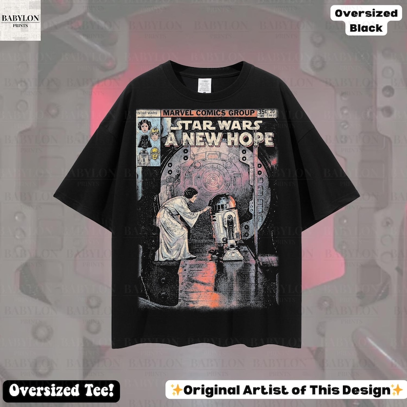 May include: Black oversized t-shirt featuring a comic book-style graphic from Star Wars: A New Hope. The design includes the title, characters, and a scene with R2-D2. The shirt has the text "Oversized Tee!" and "Original Artist of This Design".