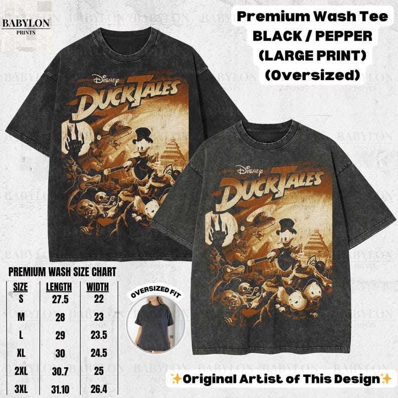 May include: Two black, oversized t-shirts with a distressed finish. Each shirt features a large graphic from Disney's DuckTales, with the show's logo and characters in shades of brown and orange. The shirts have the text "Premium Wash Tee" and a size chart.