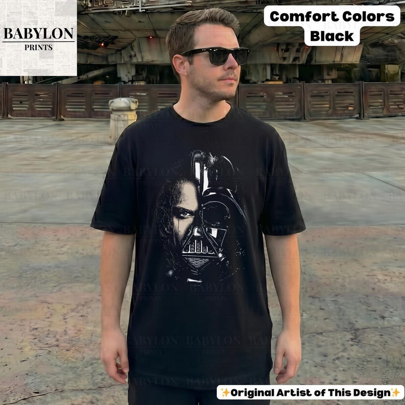 May include: Black t-shirt featuring a split image of a person and Darth Vader's mask. The shirt has the text "Comfort Colors Black" and "Original Artist of This Design". The Babylon Prints logo is in the upper left corner.