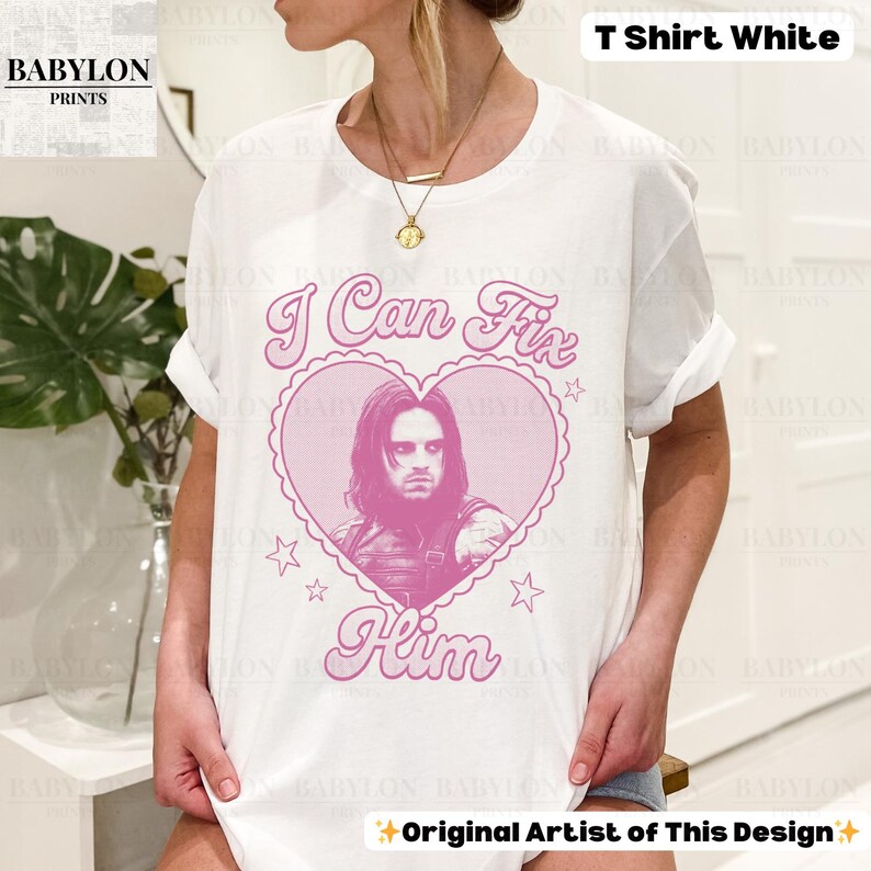 May include: White t-shirt with a pink heart-shaped graphic featuring a portrait and the text "I Can Fix Him." The shirt also has the text "Original Artist of This Design" and "T Shirt White."