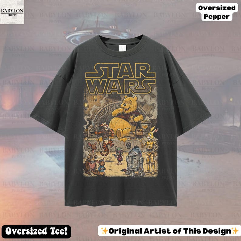 Może przedstawiać: Ciemnoszara, obszerna koszulka z nadrukiem łączącym Star Wars i Kubusia Puchatka. Złote logo Star Wars znajduje się nad ilustracją Kubusia Puchatka i jego przyjaci&oacute;ł. Koszulka zawiera r&oacute;wnież tekst "Oversized Tee!" i "Original Artist of This Design".