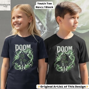 May include: Two youth t-shirts, one navy and one black, each featuring a graphic of a character with the word "DOOM" above. The character is surrounded by green energy. The text "Original Artist of This Design" is at the bottom.