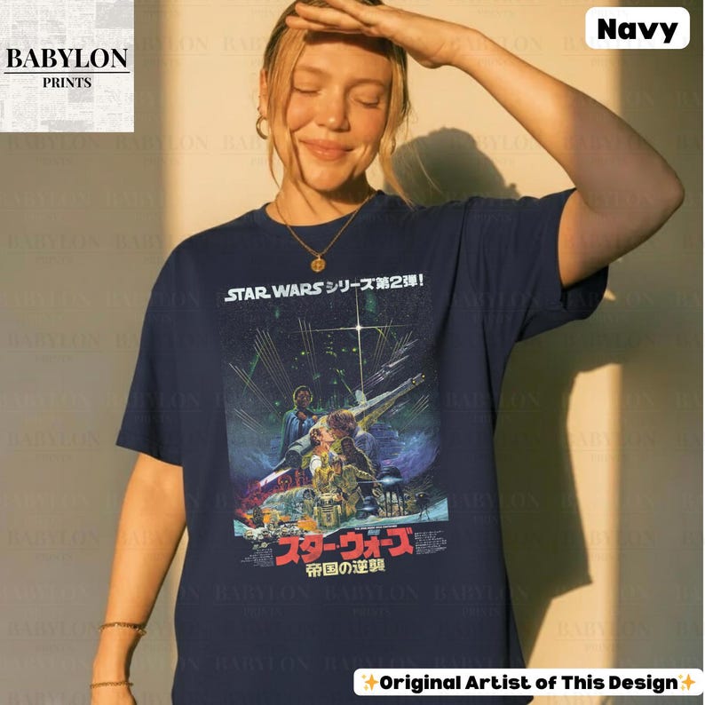 May include: Navy blue t-shirt featuring a Star Wars movie poster design. The graphic includes Japanese text and imagery from the film. The shirt has a crew neck and short sleeves. The Babylon Prints logo is visible in the upper left corner.