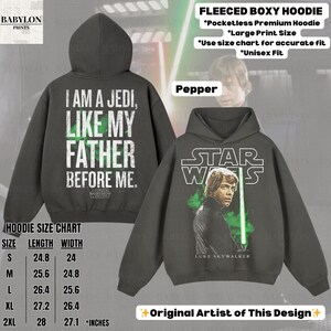 May include: A dark gray Star Wars-themed hoodie with the text "I AM A JEDI, LIKE MY FATHER BEFORE ME" on the back. The front features Luke Skywalker with a green lightsaber. The hoodie includes a size chart in inches.