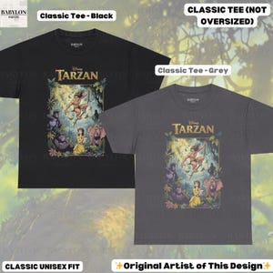 May include: Two classic unisex fit t-shirts, one black and one grey, featuring a Disney Tarzan graphic. The graphic includes Tarzan, Jane, and various jungle animals. Text on the shirts reads "Classic Tee - Black", "Classic Tee - Grey", and "Original Artist of This Design".