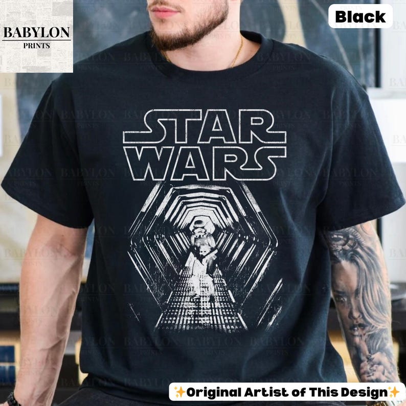 May include: Black t-shirt featuring the Star Wars logo in white block letters above a detailed graphic of a Stormtrooper in a hexagonal tunnel. The shirt is a classic crew neck style.
