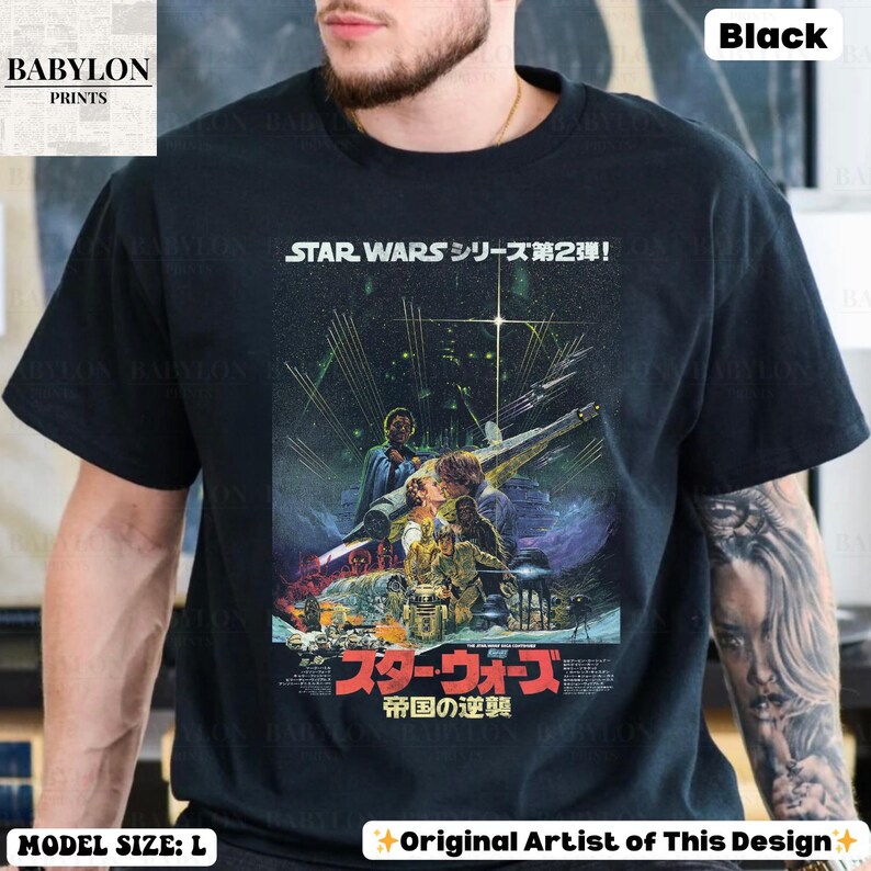 May include: Black t-shirt featuring a Star Wars movie poster design. The graphic includes Japanese text and images of characters and a spaceship. The shirt also has the text "STAR WARS シリーズ第2弾!" at the top.