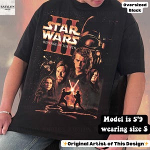 May include: Black oversized t-shirt featuring a Star Wars: Revenge of the Sith graphic. The design includes characters and the film's title in orange and white. The shirt is a size S and the model is 5'9.