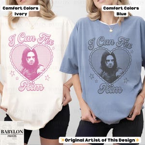 May include: Two t-shirts, one ivory and one blue, with the text "I Can Fix Him" and a heart-shaped graphic featuring a person's portrait. The shirts are labeled "Comfort Colors" and "Original Artist of This Design."