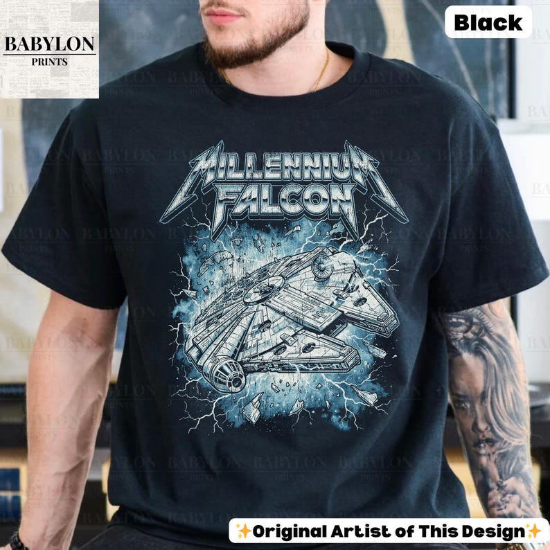 May include: Black t-shirt featuring a graphic of the Millennium Falcon spaceship with the text "Millennium Falcon" in a metal band style font. The design includes blue lightning and the text "Original Artist of This Design."