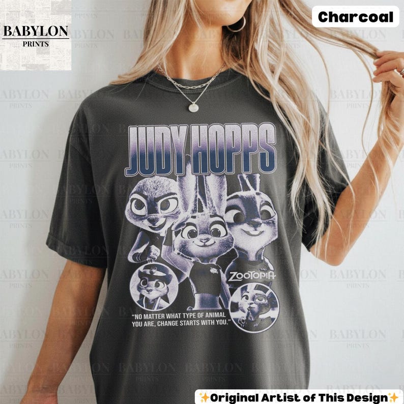 May include: Charcoal-colored t-shirt featuring the text "JUDY HOPPS" above a graphic of characters from the movie Zootopia. The shirt also includes the quote, "NO MATTER WHAT TYPE OF ANIMAL YOU ARE, CHANGE STARTS WITH YOU."
