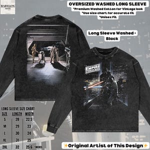 May include: Black long-sleeve shirt with a distressed wash, featuring a Star Wars scene on the front and back. The front graphic displays a battle scene with the text "EMPIRE STRIKES BACK." The back shows a scene with C-3PO and R2-D2. The shirt is oversized and has a size chart.