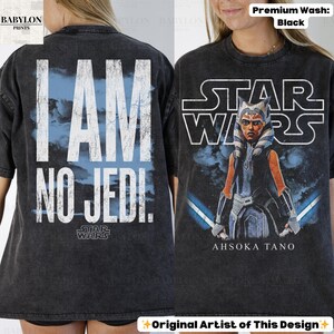 May include: Black t-shirt featuring a Star Wars design. The front displays Ahsoka Tano with lightsabers, and the back reads "I AM NO JEDI." The shirt has a distressed look and the text "STAR WARS" is visible.