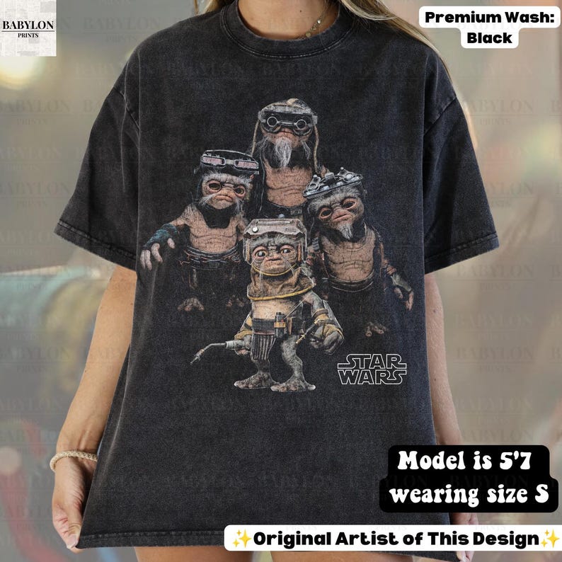May include: A black acid-wash t-shirt featuring a graphic print of four Ewok characters from Star Wars. The design includes the Star Wars logo in white text. The shirt has a crew neckline and short sleeves, showcasing a vintage-inspired aesthetic.