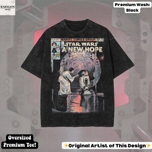 May include: Black oversized t-shirt featuring a comic book-style graphic from Star Wars: A New Hope. The design includes Princess Leia and R2-D2. The shirt has the text "STAR WARS A NEW HOPE" and "MARVEL COMICS GROUP".