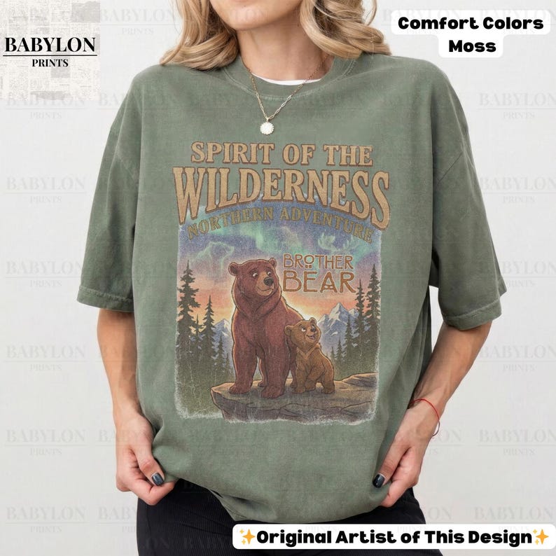 May include: A moss green t-shirt with a graphic of two bears and the text "Spirit of the Wilderness Northern Adventure Brother Bear." The shirt also has the text "Comfort Colors Moss" and "Original Artist of This Design."