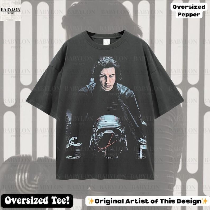 May include: Dark grey oversized tee with a graphic of a character from a science fiction film. The design includes a portrait and a helmet. The shirt has the text "Oversized Tee!" and "Original Artist of This Design".