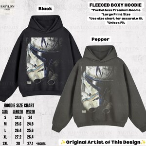 May include: Two pocketless, fleeced, boxy hoodies in black and pepper gray, each featuring a large graphic print of a white and blue clone trooper helmet. A size chart with length and width measurements in inches is included for reference.