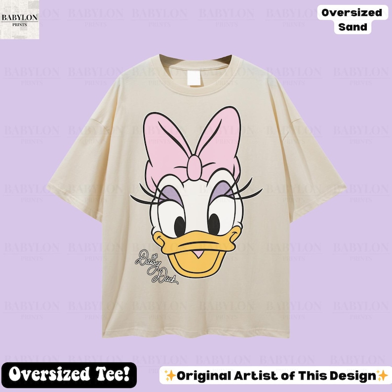 Puede incluir: Camiseta de gran tama&ntilde;o de color arena con un gr&aacute;fico de Daisy Duck. El dise&ntilde;o incluye un lazo rosa, pesta&ntilde;as y el texto "Daisy Duck". La camiseta tiene mangas cortas y cuello redondo. Tambi&eacute;n se ve el texto "Oversized Tee!" y "Original Artist of This Design".