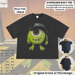 K&ouml;nnte beinhalten: Schwarzes, &uuml;bergro&szlig;es Boxy-T-Shirt mit einer Grafik von Mike Wazowski aus Monsters, Inc. Das T-Shirt hat einen Rundhalsausschnitt und kurze &Auml;rmel. Das Shirt enth&auml;lt den Text "Boxy Tee - Black" und "Original Artist of This Design".