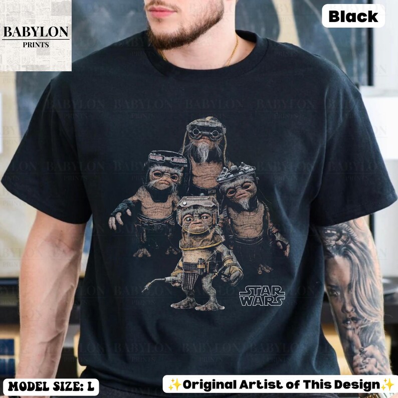 Op de afbeelding: Een zwart T-shirt met korte mouwen en een grafische print van vier Ewok-personages uit Star Wars. De personages staan in een groep, waarbij er &eacute;&eacute;n op de voorgrond een gereedschap vasthoudt. Het Star Wars-logo is in het wit gedrukt.