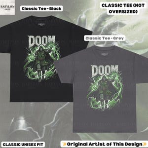 May include: Black and grey classic unisex fit t-shirts featuring a graphic of a character with the word "DOOM" in white. The character is in green and the design has green lightning effects. The text "Classic Tee" is also visible.